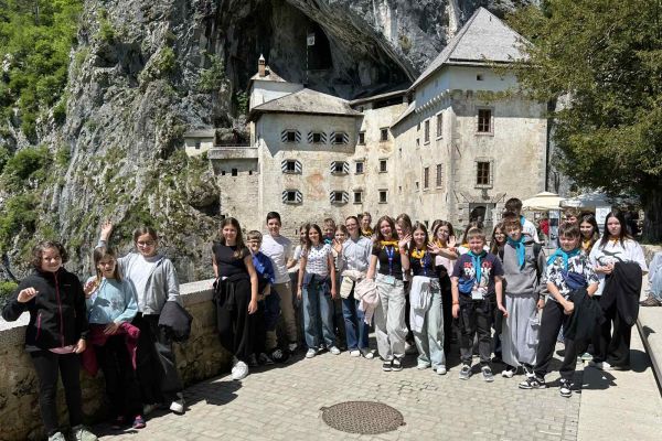 Učenci OŠ Artiče in gosti iz Poljske pred Predjamskim gradom